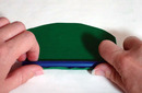 Pressing bottom edge of clay sheet onto pen